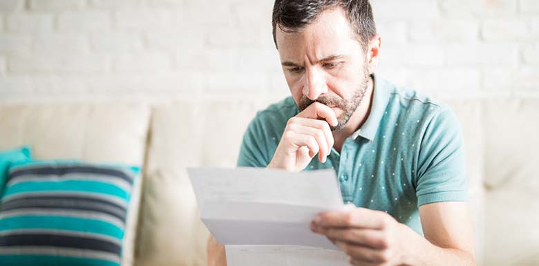 Man upset while reading insurance letter