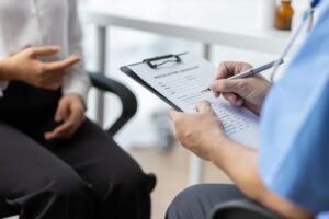 Doctor and female patient discussing in examination room at hospital.