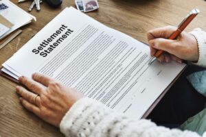 A lady signing insurance settlement paper