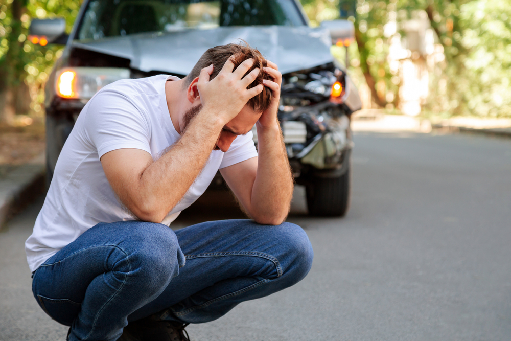 man clutching head after car wreck