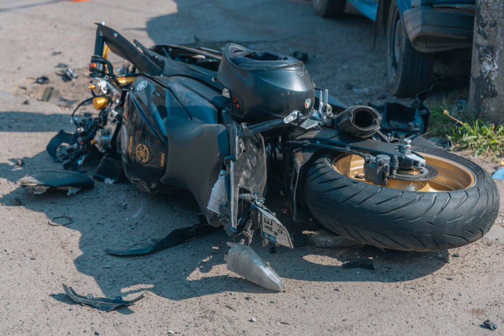 A damaged motorcycle lies on the road after a severe collision, with visible signs of the accident. The scene depicts the aftermath of a traffic accident in Dnipro, Ukraine, on August 02, 2023.